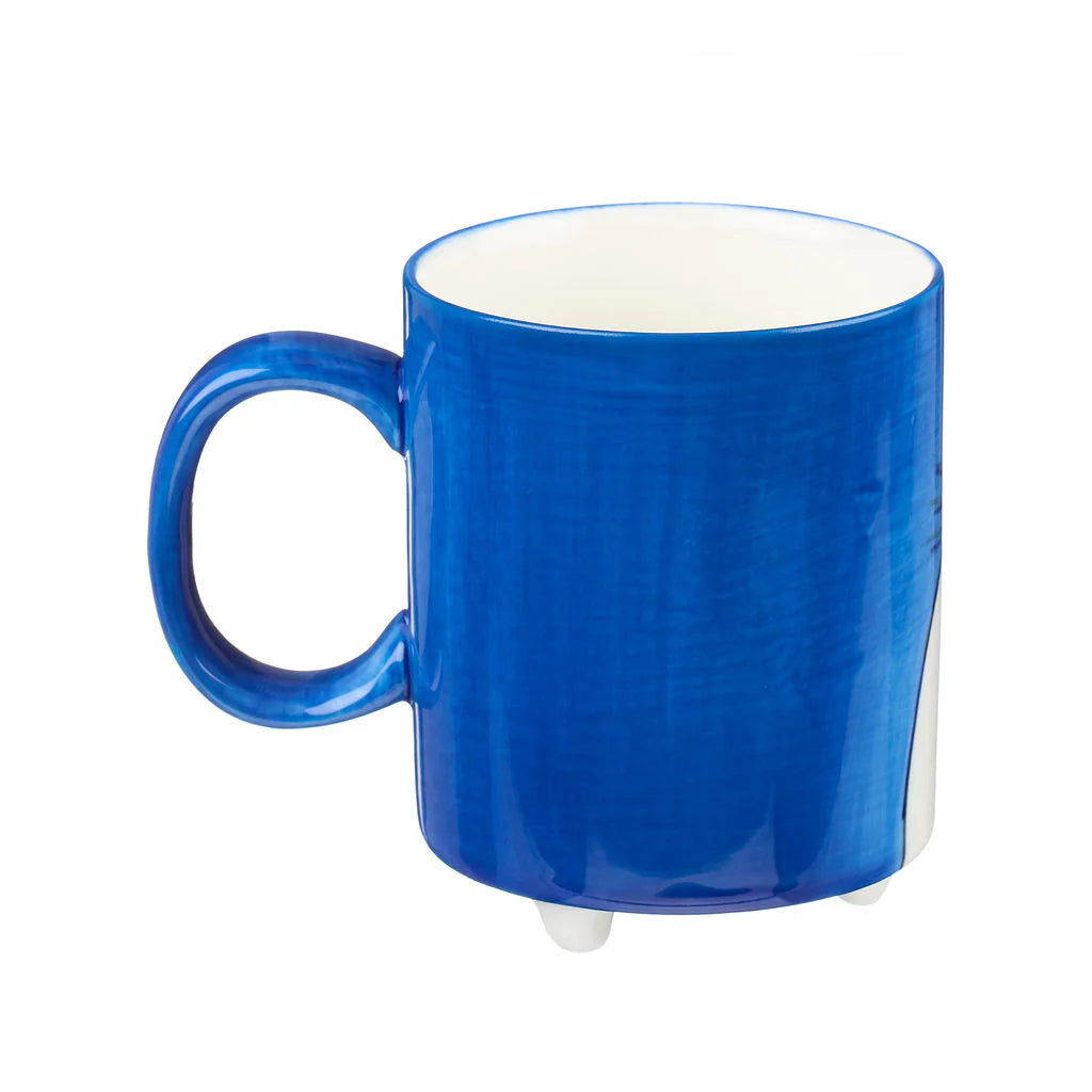 Blue ceramic mug with a handle and three small feet.  The mug has a slightly textured surface.