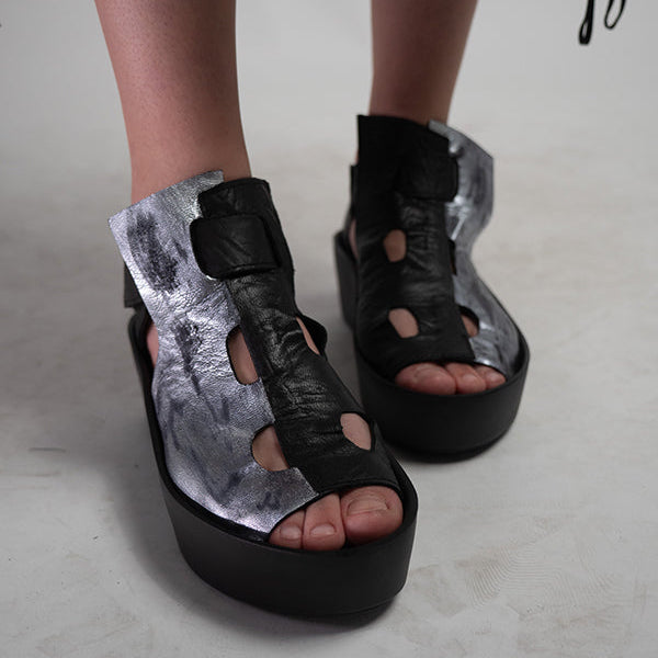 Platform sandals with black and silver leather, featuring cut-out detailing and ankle straps.
