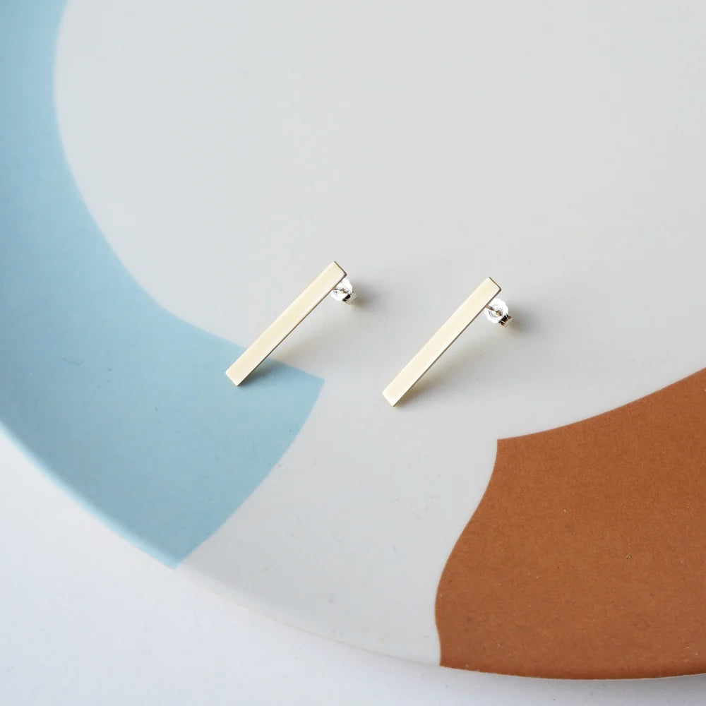 Pair of gold bar stud earrings.