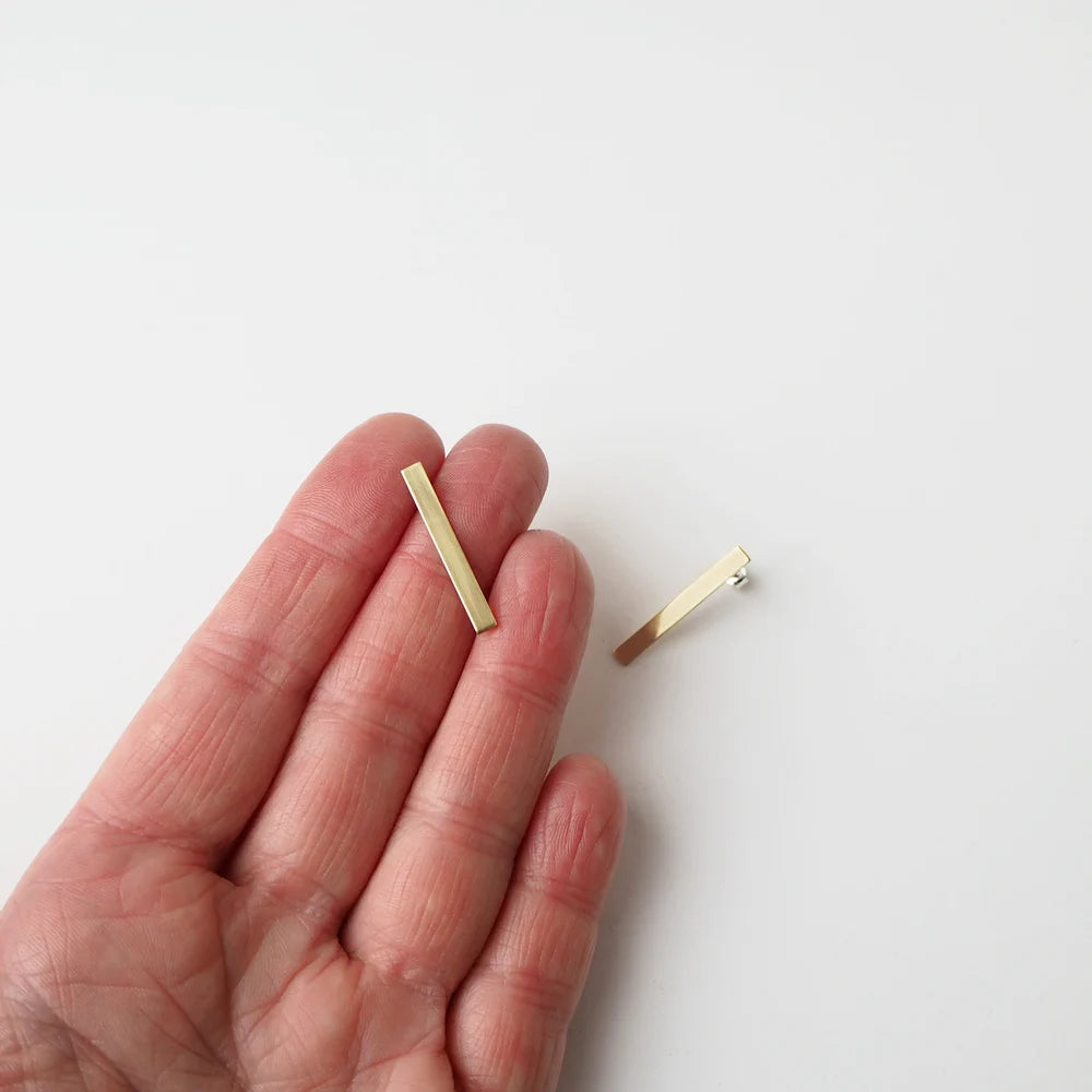 Pair of gold bar stud earrings.  Minimalist design.