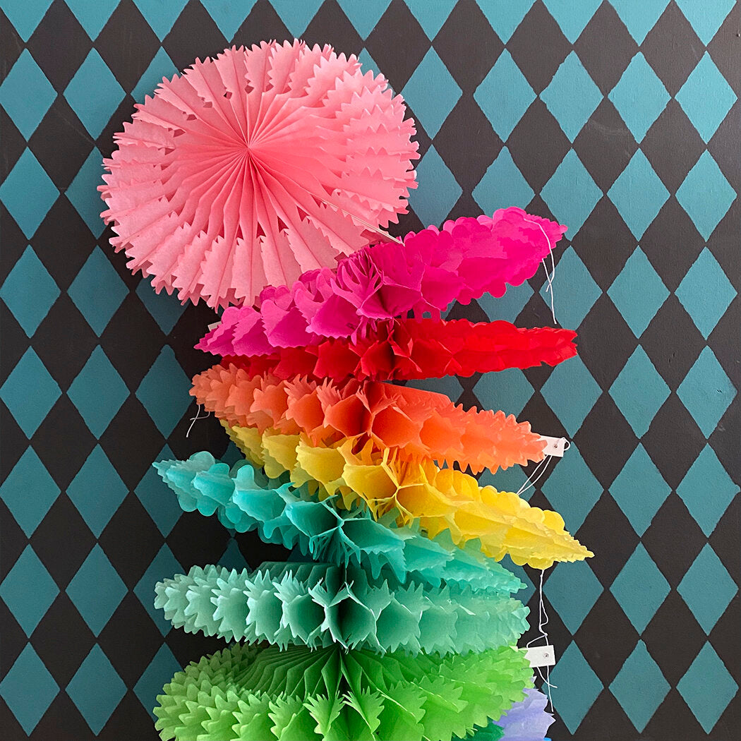 Rainbow-colored tissue paper honeycomb and fan decorations.