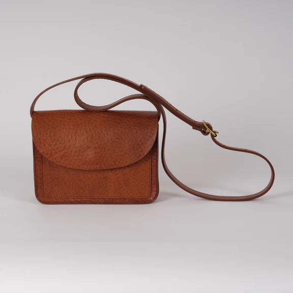 Brown leather crossbody bag with a flap closure and textured surface.  The strap is adjustable.
