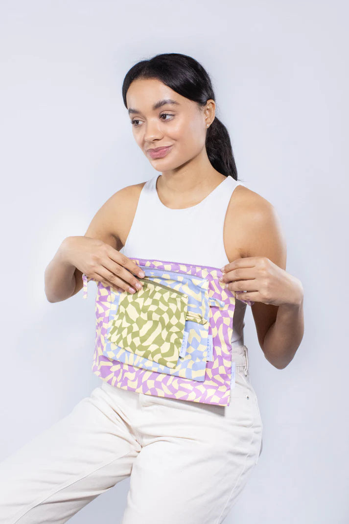 Set of three reusable fabric pouches in pastel purple, yellow, and blue abstract patterns.