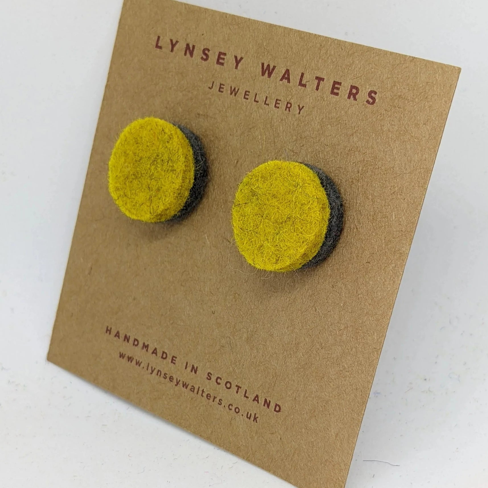 Pair of handmade felt earrings.  Bright yellow circles layered on dark gray felt.
