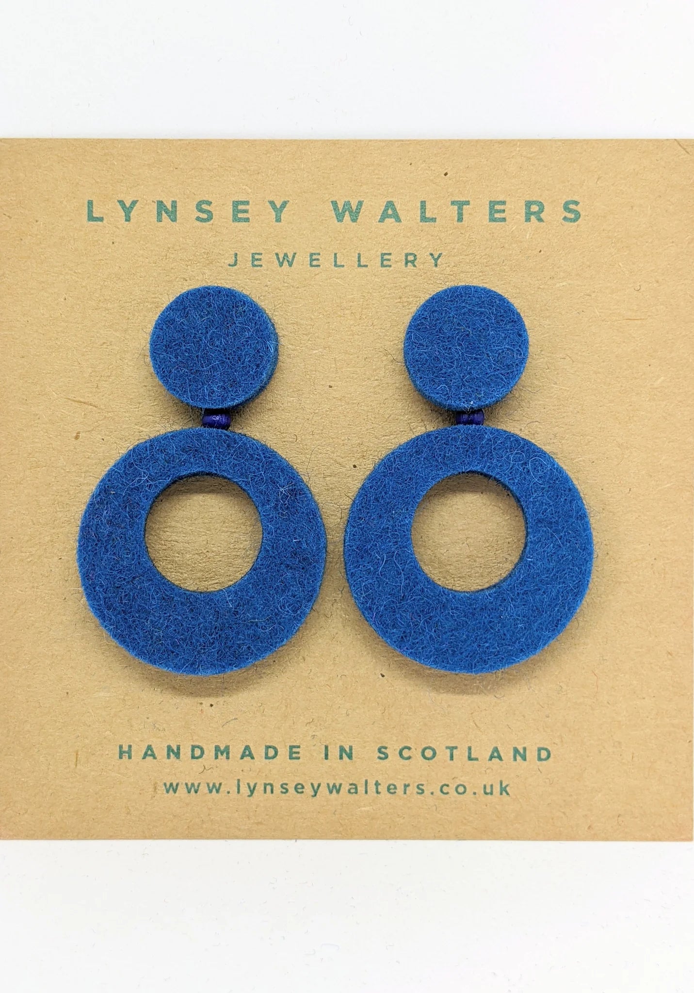 Pair of cobalt blue felt earrings. Each earring features a small circle atop a larger circle with a central hole.