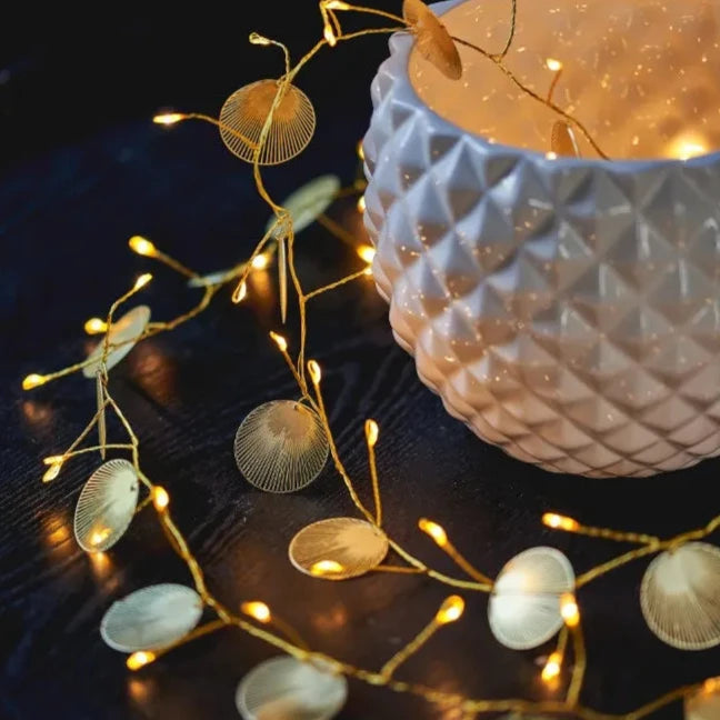 Gold fairy lights with decorative metallic leaf accents.