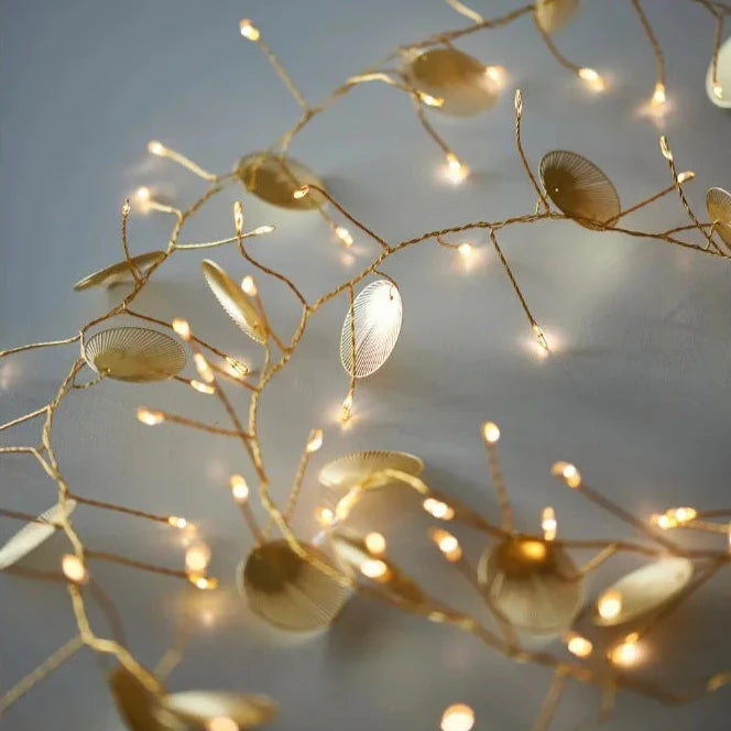 Gold LED string lights with decorative metallic leaf accents.
