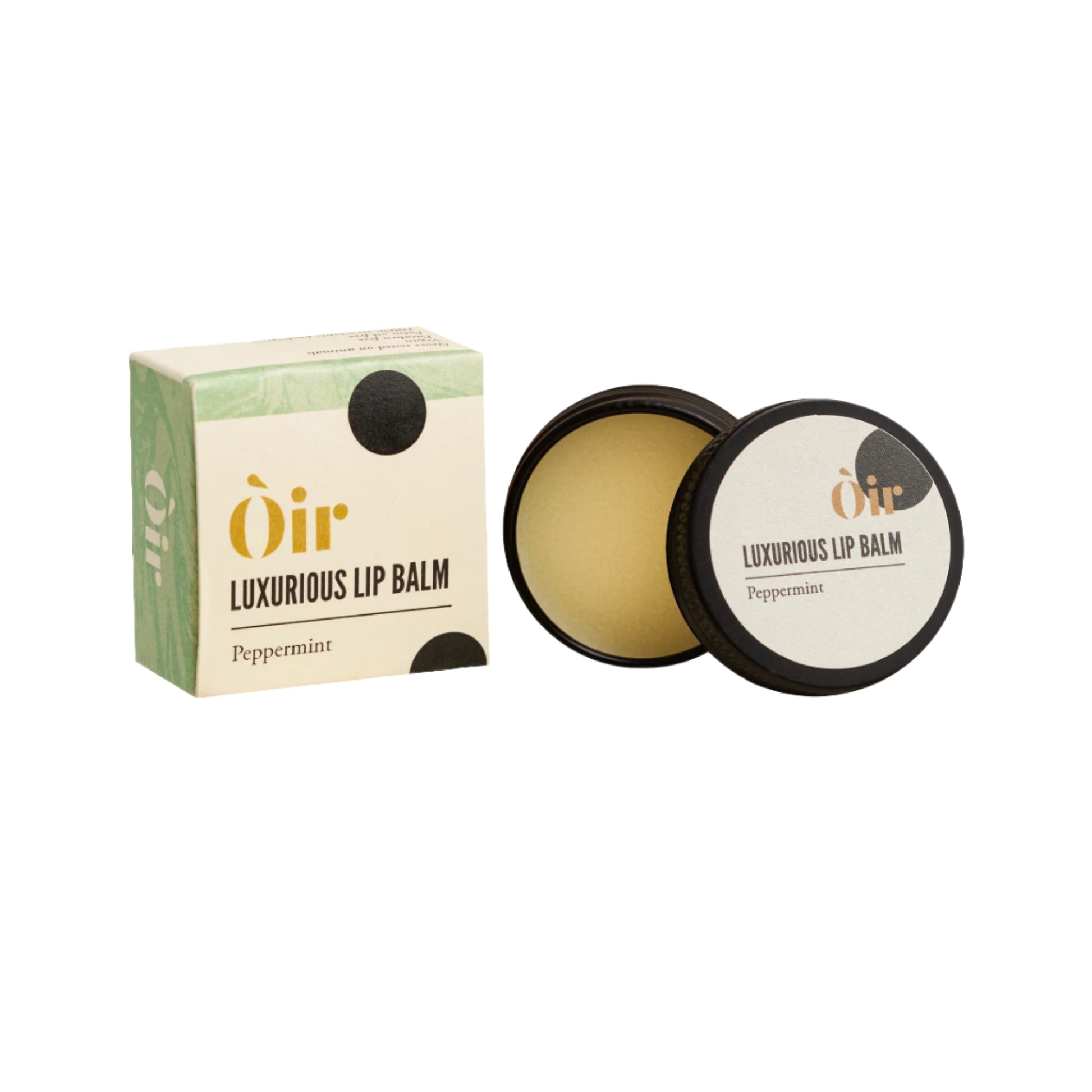 A metal tin and cardboard box of Oir luxurious lip balm with peppermint, next to its lid.