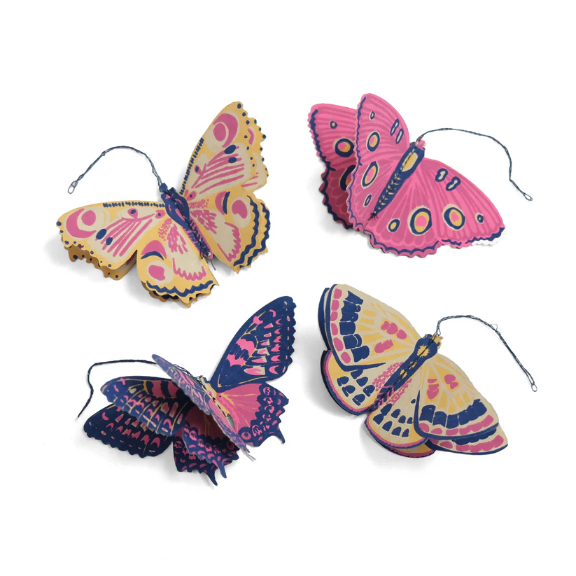 Set of four decorative paper butterflies.  Pink, yellow, and navy blue designs.  Intricate wing patterns. Hanging ornaments.