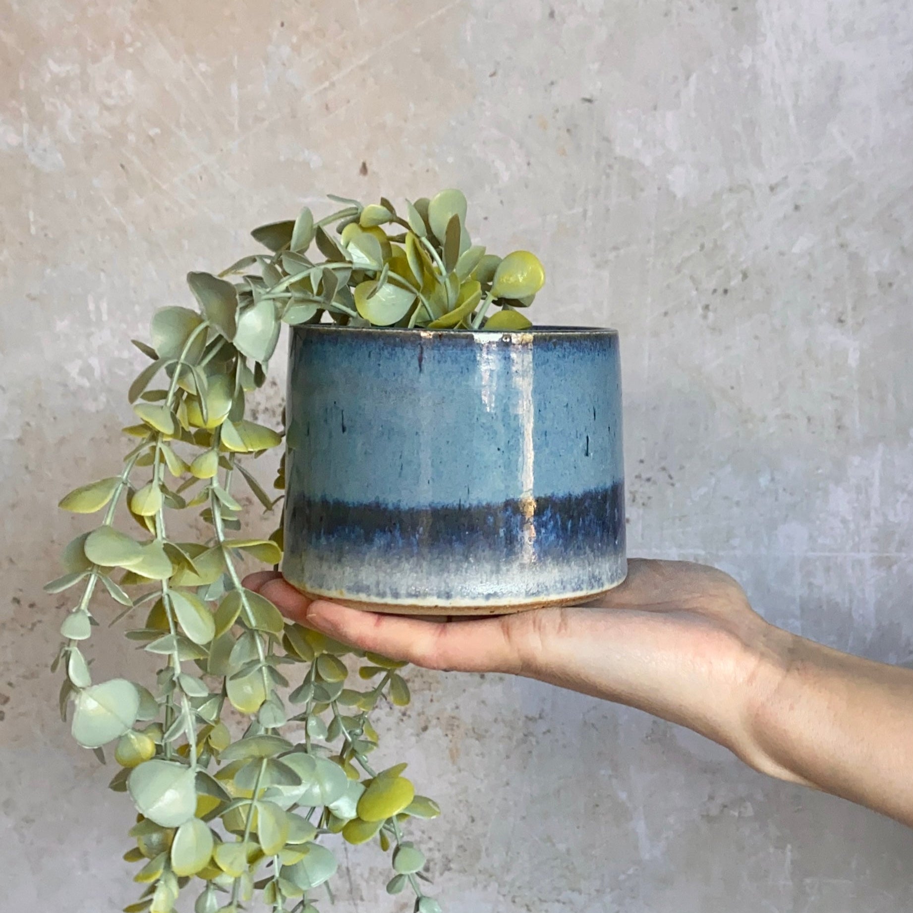 Small, cylindrical ceramic planter with a blue-to-dark-blue gradient glaze and a light-colored base.
