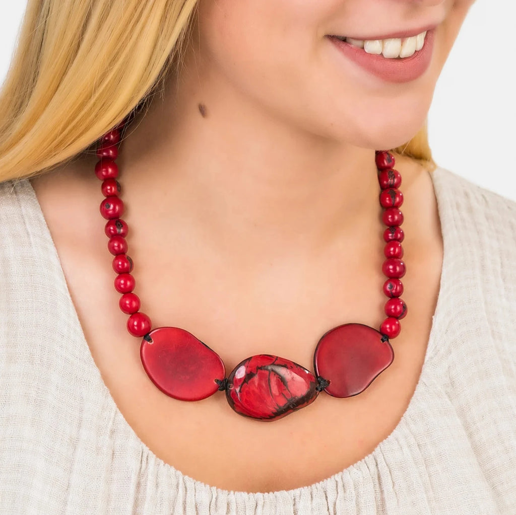 Red beaded necklace with three larger, irregularly shaped red stone accents.