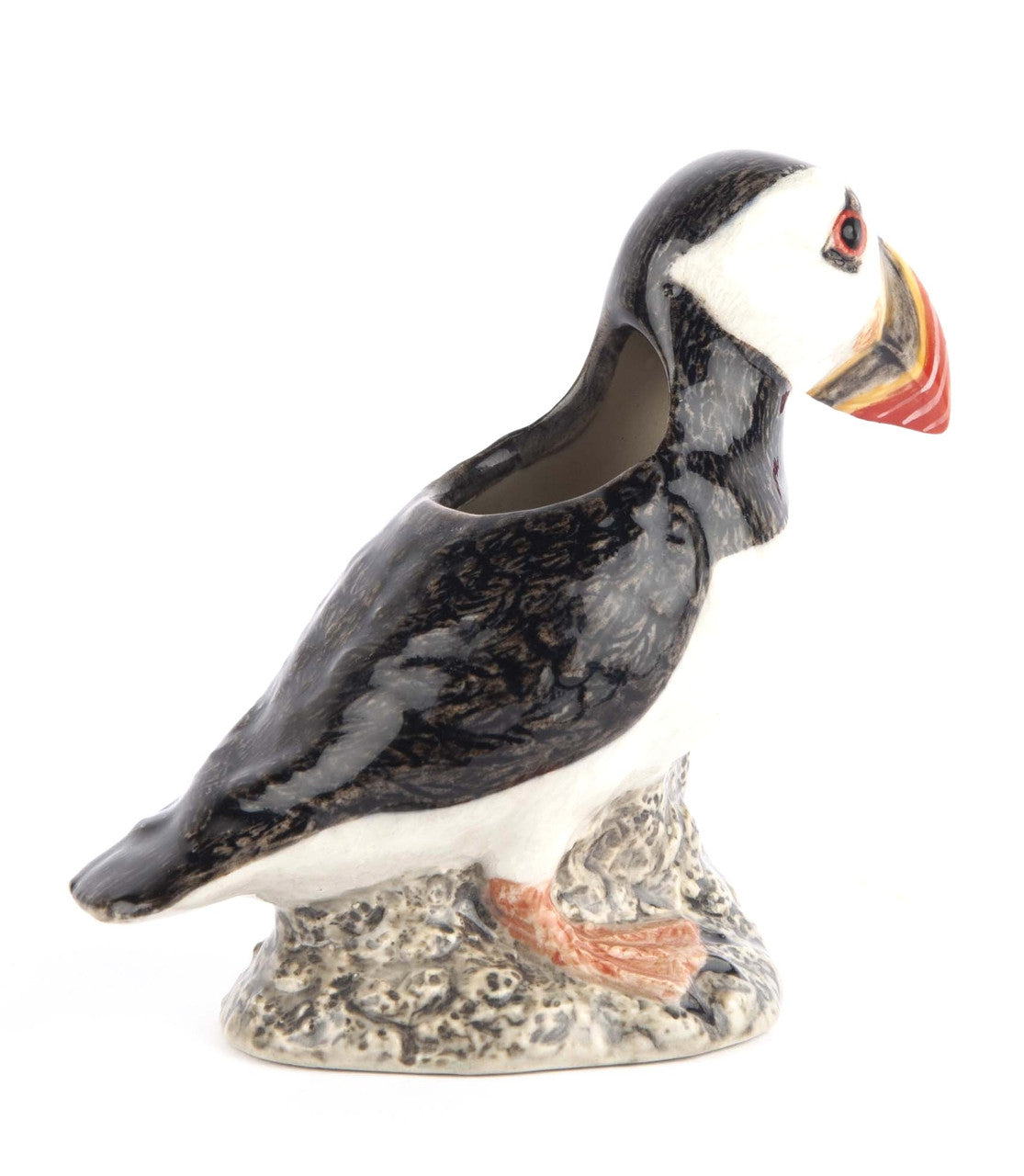 Ceramic puffin planter, black and white with orange beak, perched on a textured base.