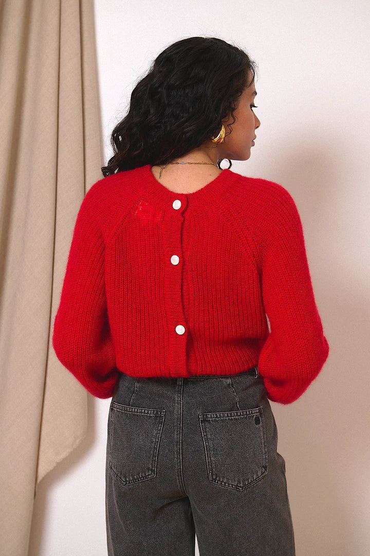 Red button-up knitted cardigan with balloon sleeves and a relaxed fit.