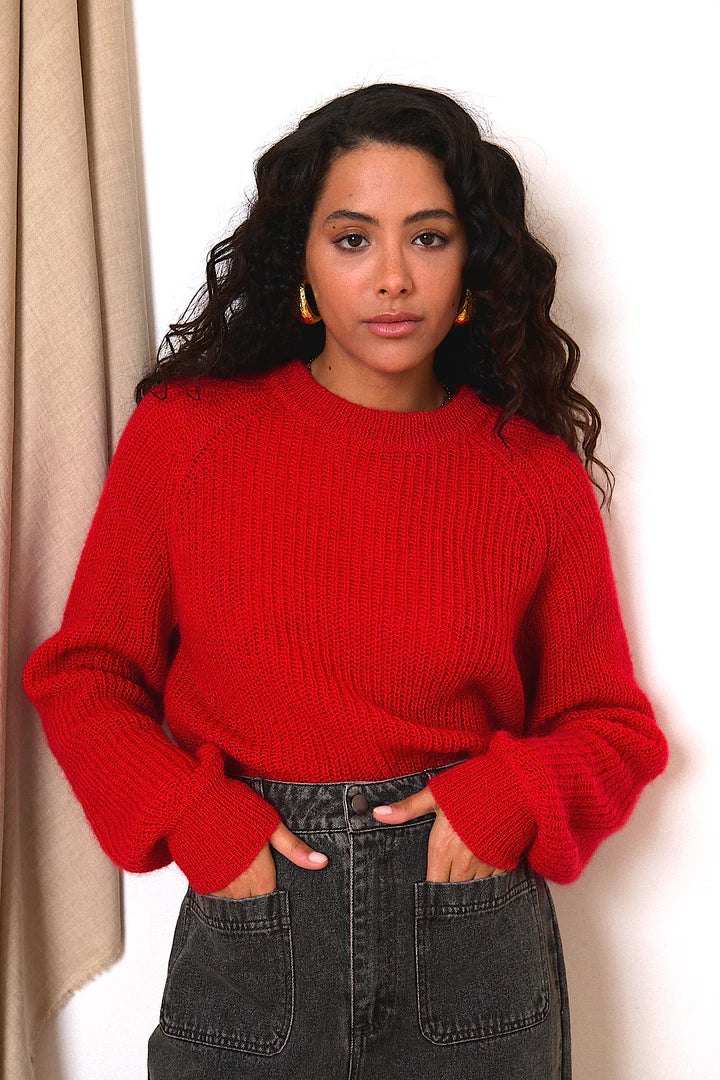 Red ribbed knit sweater with balloon sleeves.