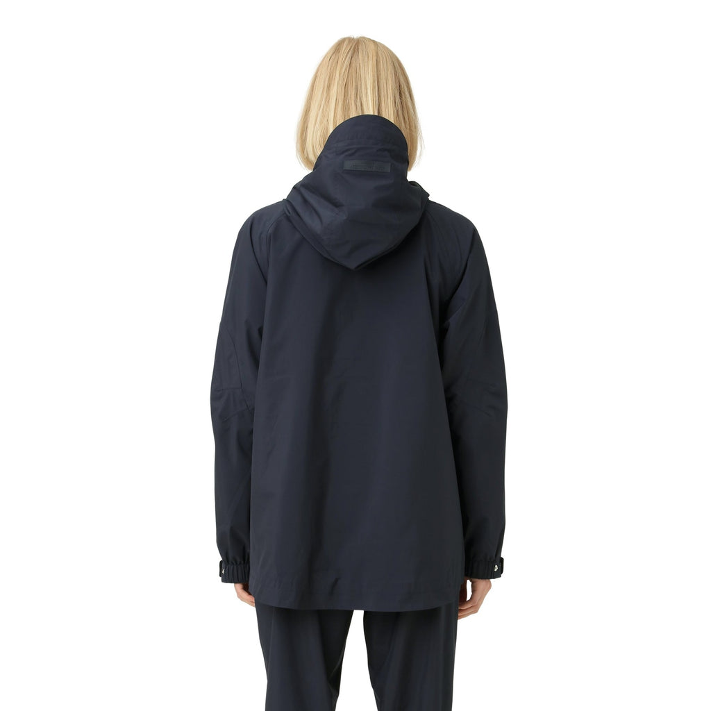 Rear view of a woman wearing a dark navy blue hooded jacket with cinched cuffs. The jacket appears to be made of a smooth,