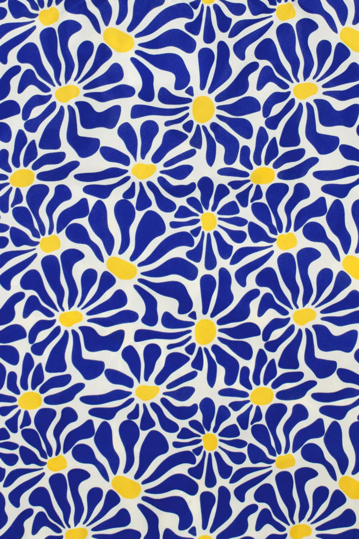 Blue and yellow stylized floral fabric pattern.  The design features repeating daisy-like flowers on a white background.