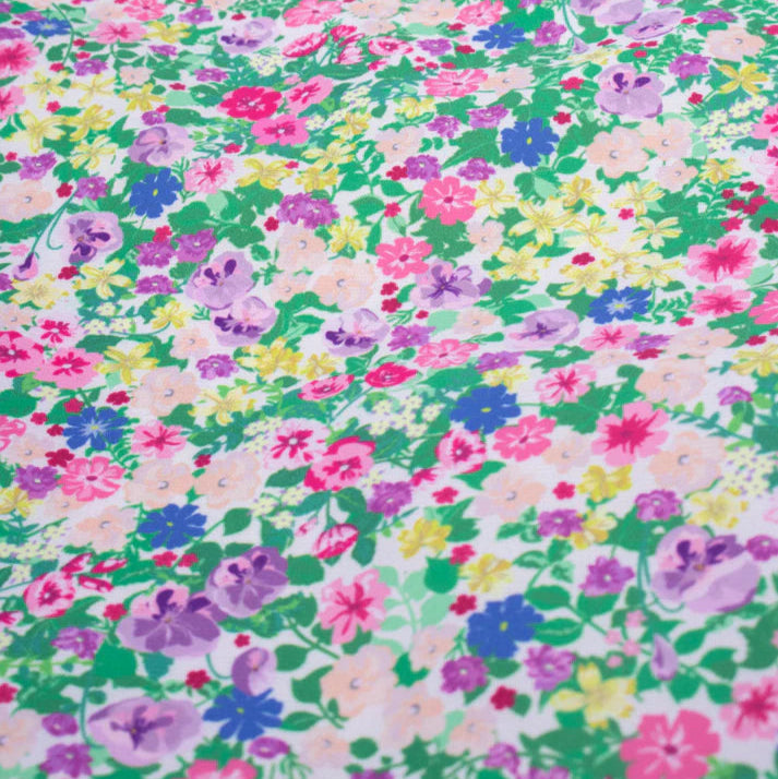White fabric with a dense, multicolored floral print.