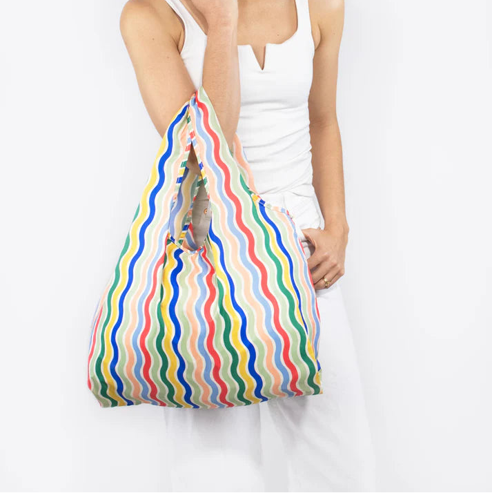 Reusable shopping bag with multicolored wavy stripes.