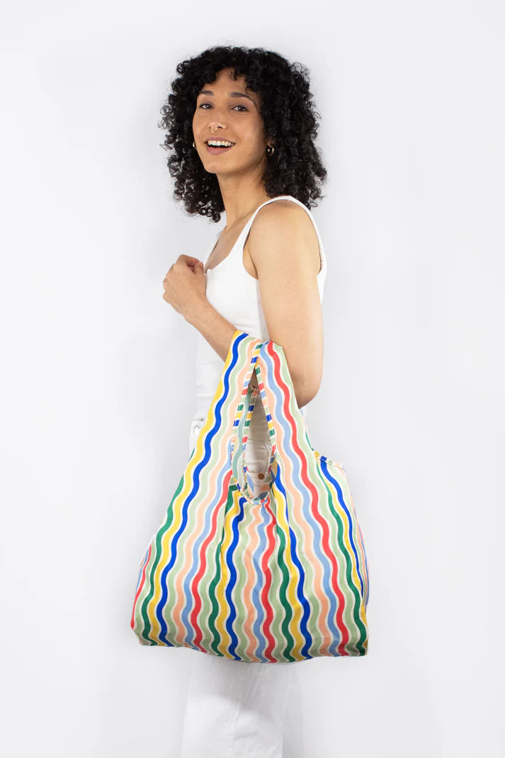 Reusable shopping bag with multicolored wavy stripes.