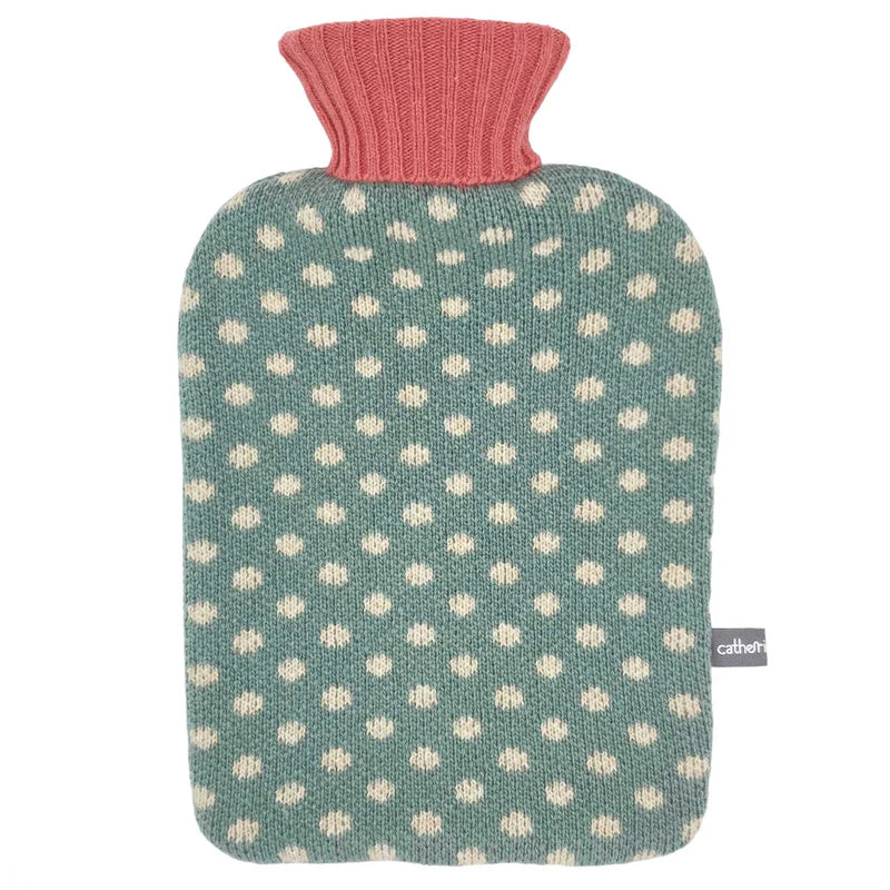 Teal knitted hot water bottle with white polka dots and a coral ribbed collar.