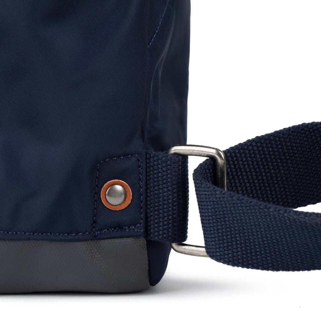 Navy blue bag with a strap and metal buckle on a white background