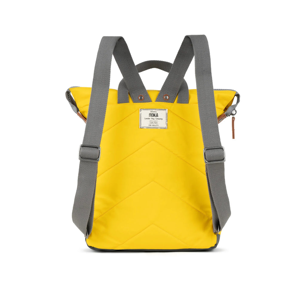 Yellow quilted backpack with gray straps and a small brown leather zipper pull.