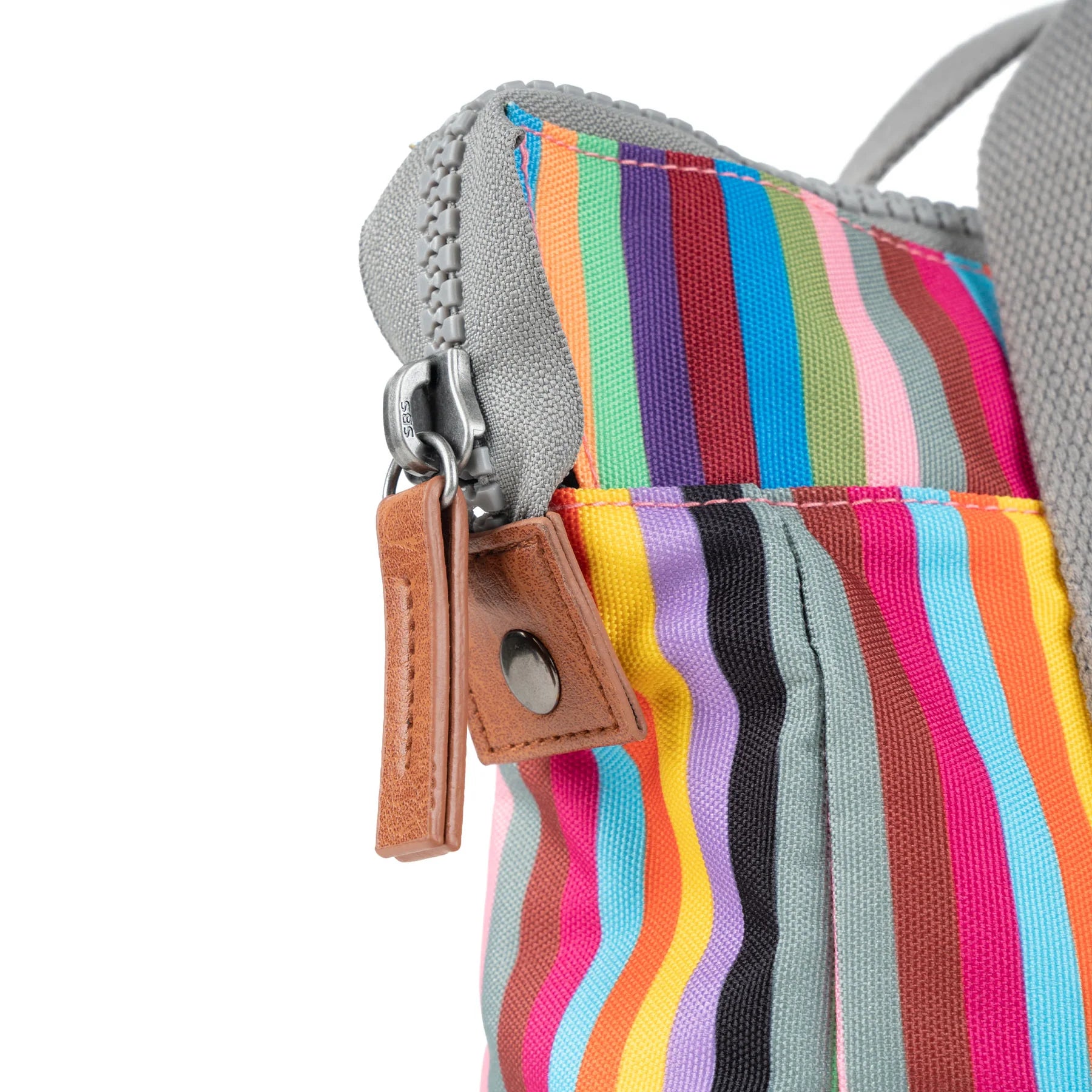 Close-up of a multicolored striped tote bag's zipper and pull.