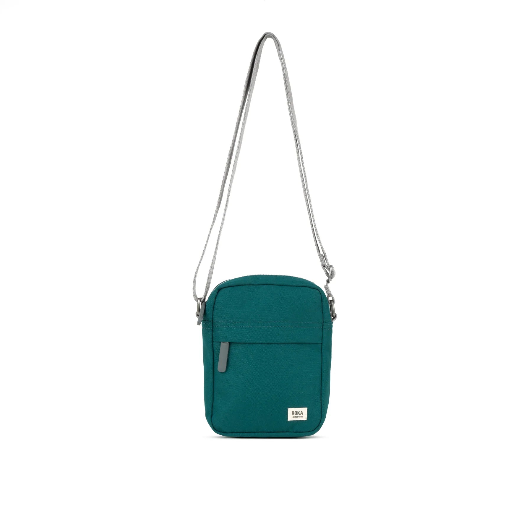 A teal Bond Pocket Crossbody bag made from recycled canvas with a zippered top, an extra external pocket, and an adjustable strap. It features a main compartment and an additional mesh pocket inside.