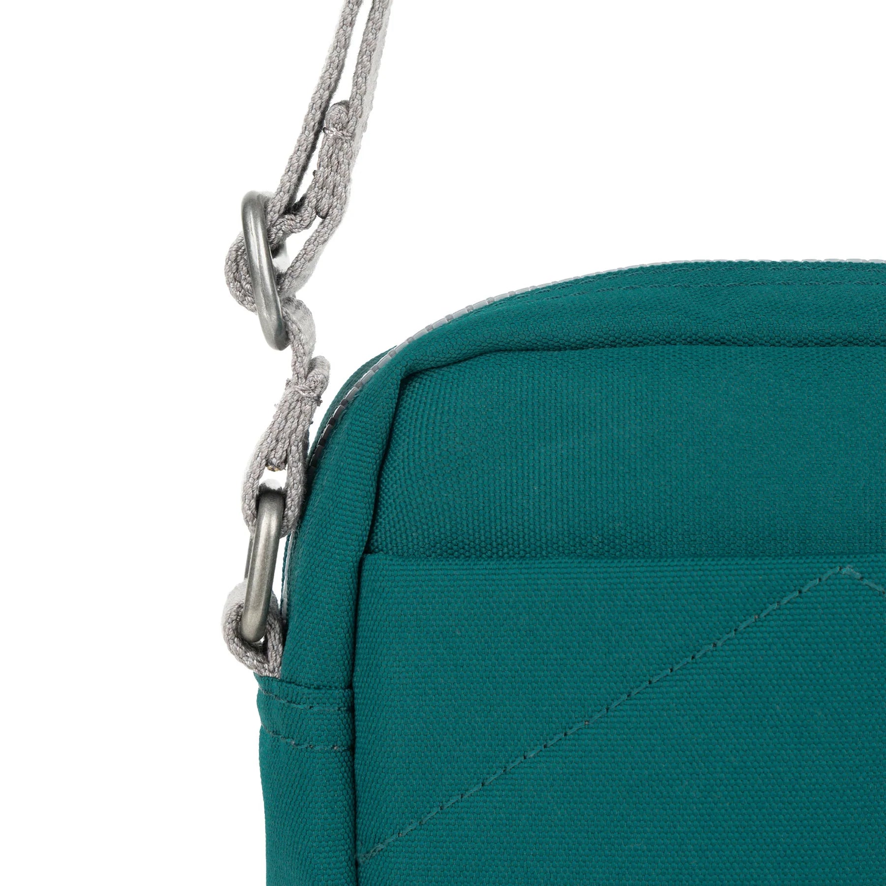 A teal Bond Pocket Crossbody bag made from recycled canvas with a zippered top, an extra external pocket, and an adjustable strap. It features a main compartment and an additional mesh pocket inside.