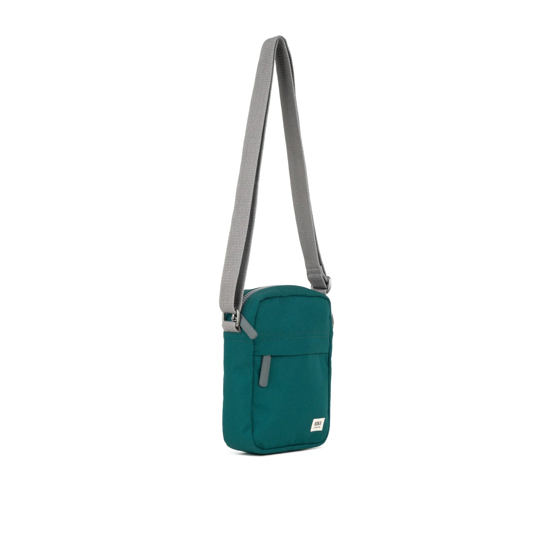 A teal Bond Pocket Crossbody bag made from recycled canvas with a zippered top, an extra external pocket, and an adjustable strap. It features a main compartment and an additional mesh pocket inside.