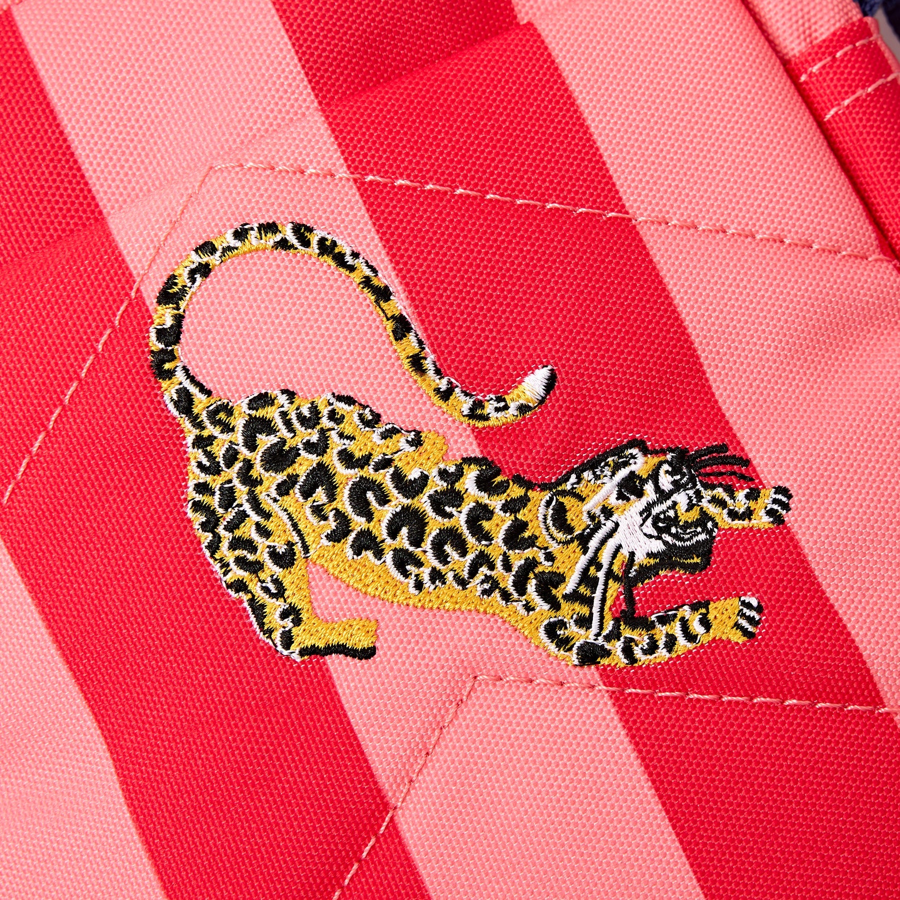 Leopard embroidery on a pink and red striped fabric