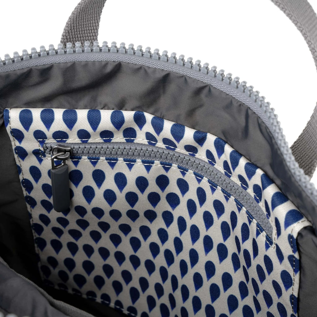 Close-up of a ROKA bag interior, featuring a zippered pocket and a navy droplet-patterned lining.