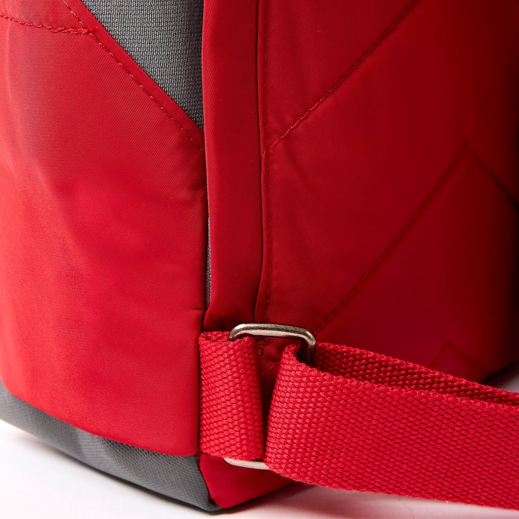 Close-up of a red backpack with a strap on a white background