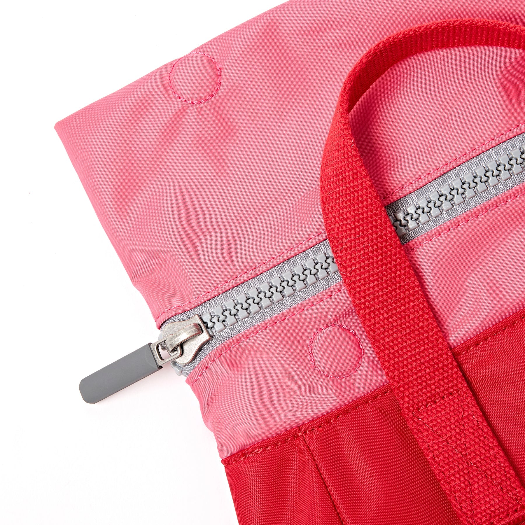 Close-up of a pink and red jacket with a zipper on a white background
