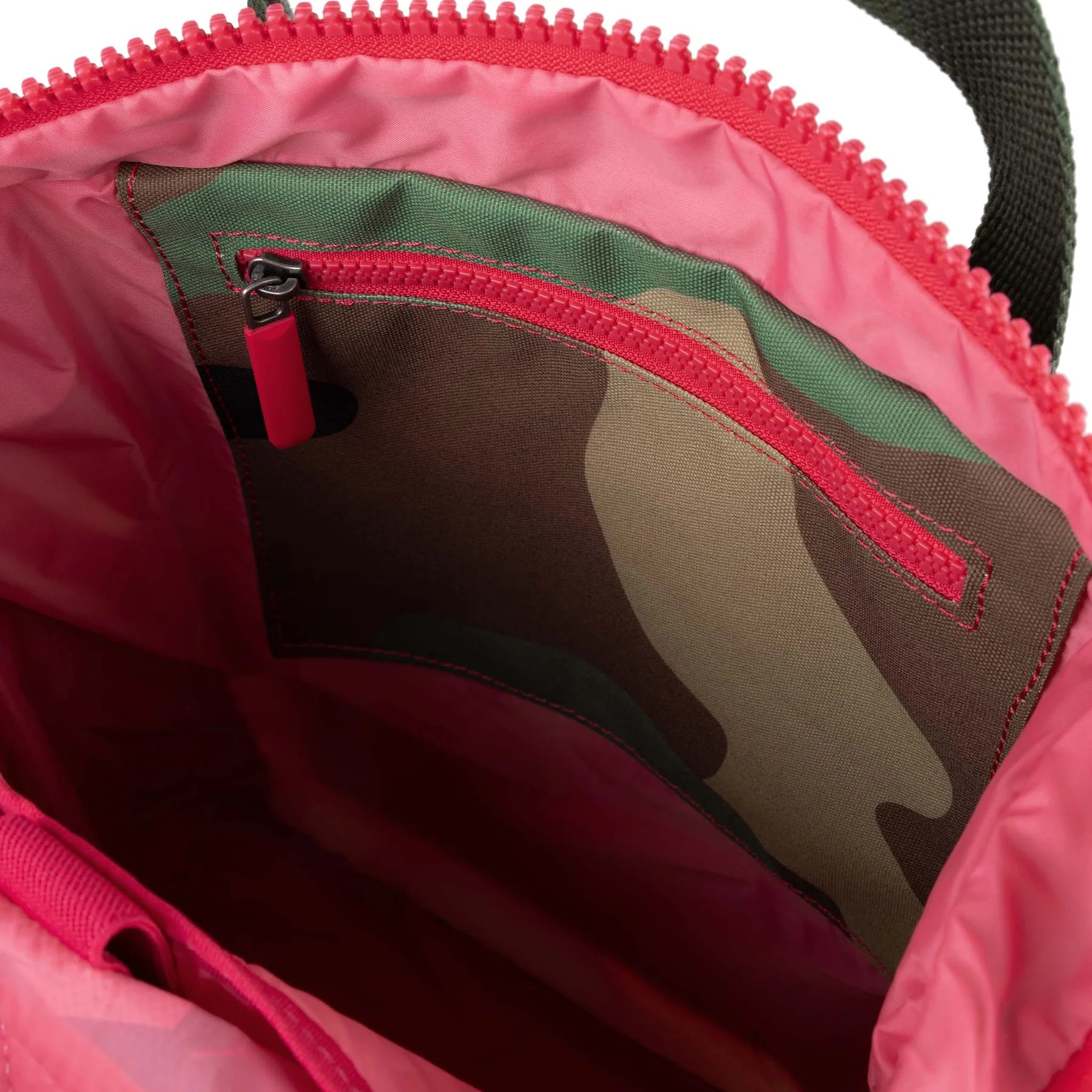 Close-up of a pink bag with a camouflage lining and red zipper.