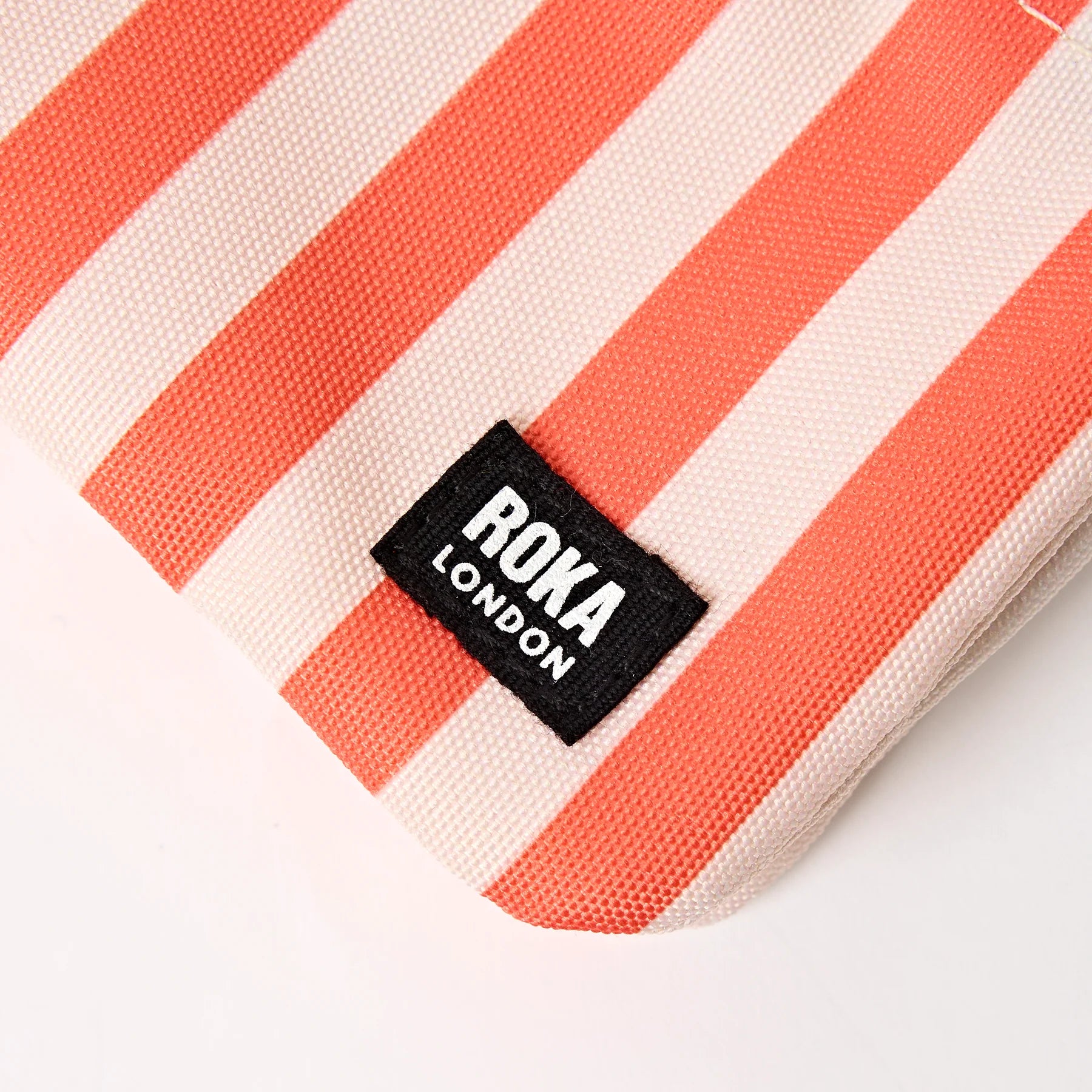 Striped bag with Roka London label on a white background