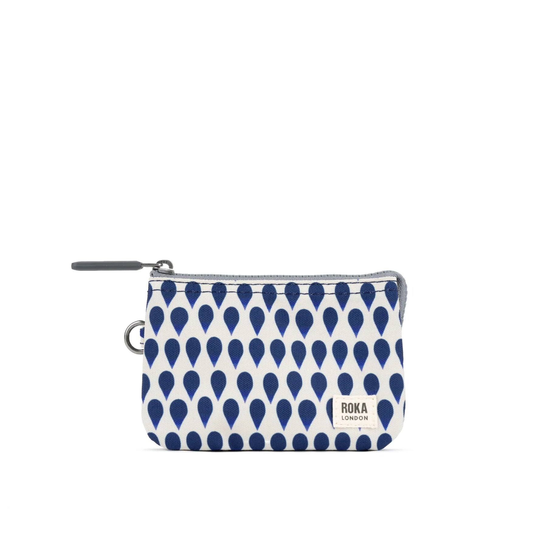White pouch with blue drop pattern and ROKA London logo on the front. Zipper closure and a keyring attachment.