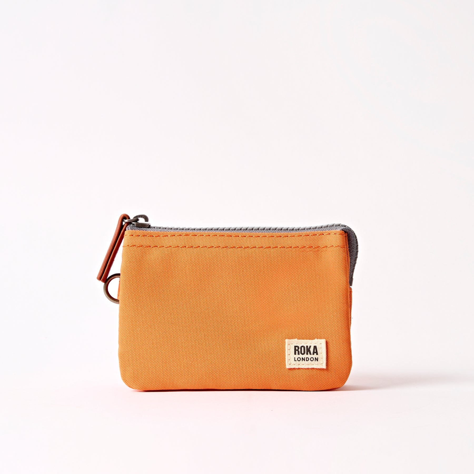 Orange wallet with a visible brand label on a white background