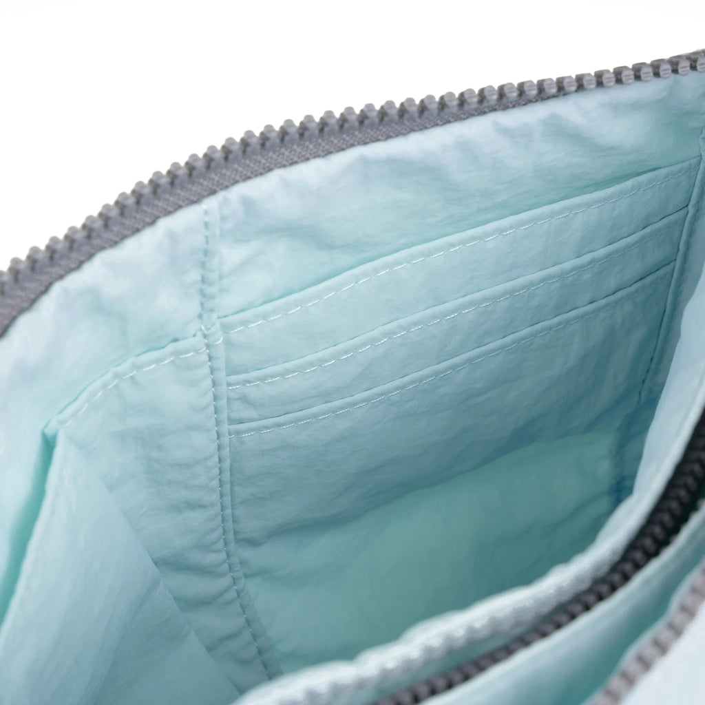 Close-up of ROKA bag interior featuring a light blue lining and organized pockets.