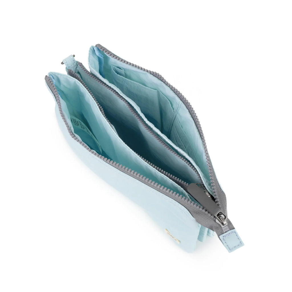 Flat lay of a light blue ROKA pouch showing two compartments with gray zippers.
