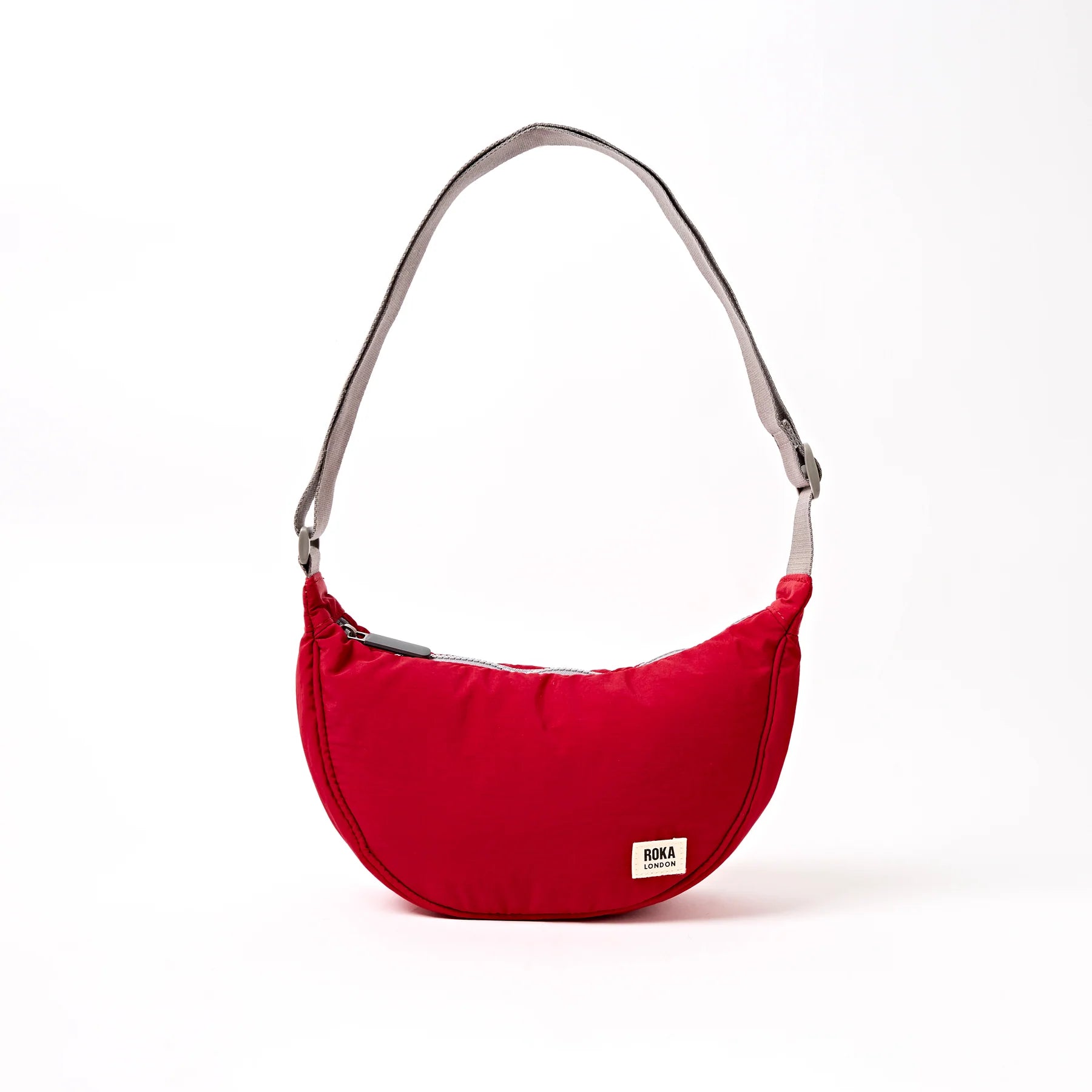Red shoulder bag with a visible brand label on a white background