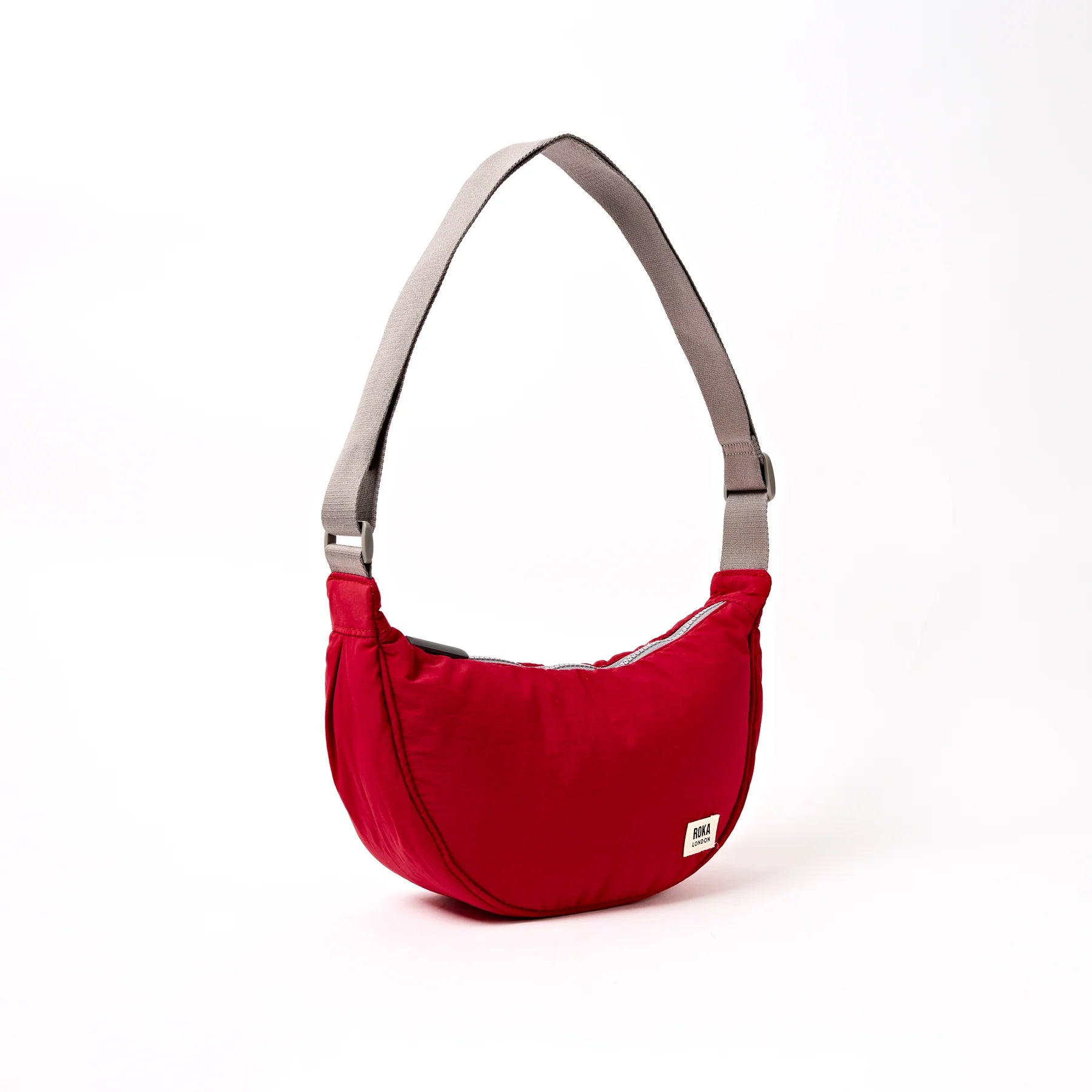 Red shoulder bag with a visible brand label on a white background