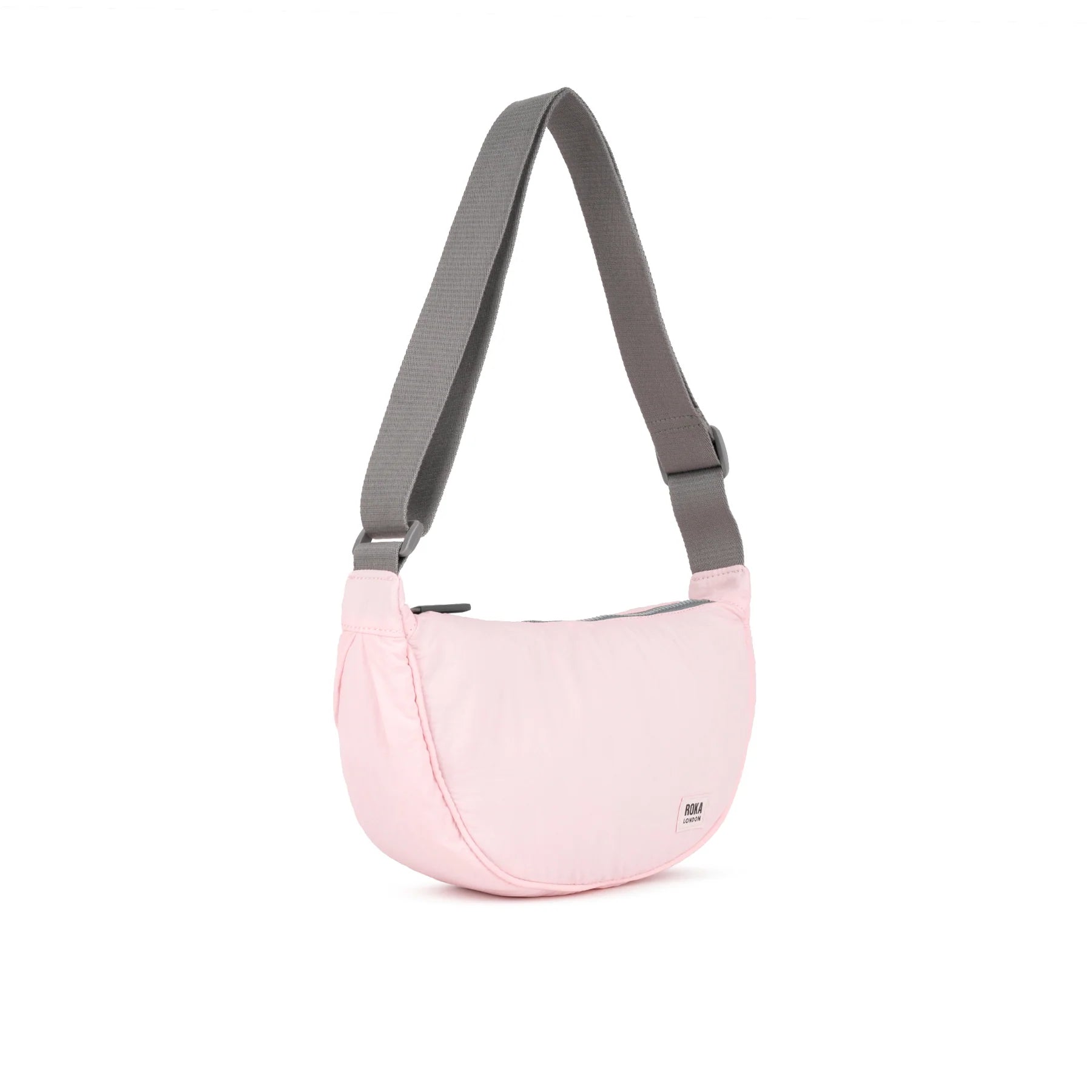 ROKA stylish pink crossbody bag with a gray strap, featuring a sleek and minimalist design.