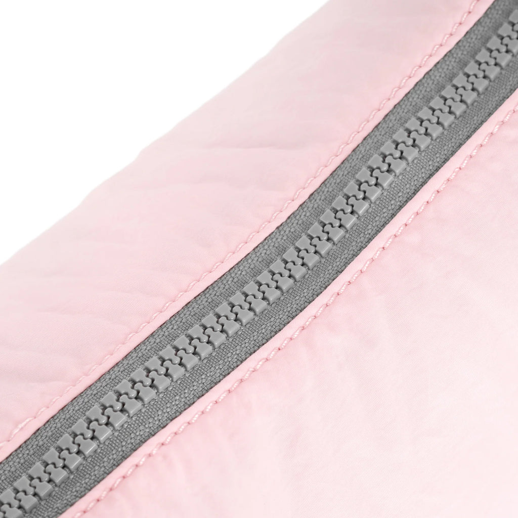 Close-up of a soft pink fabric with a gray zipper, featuring ROKA branding.