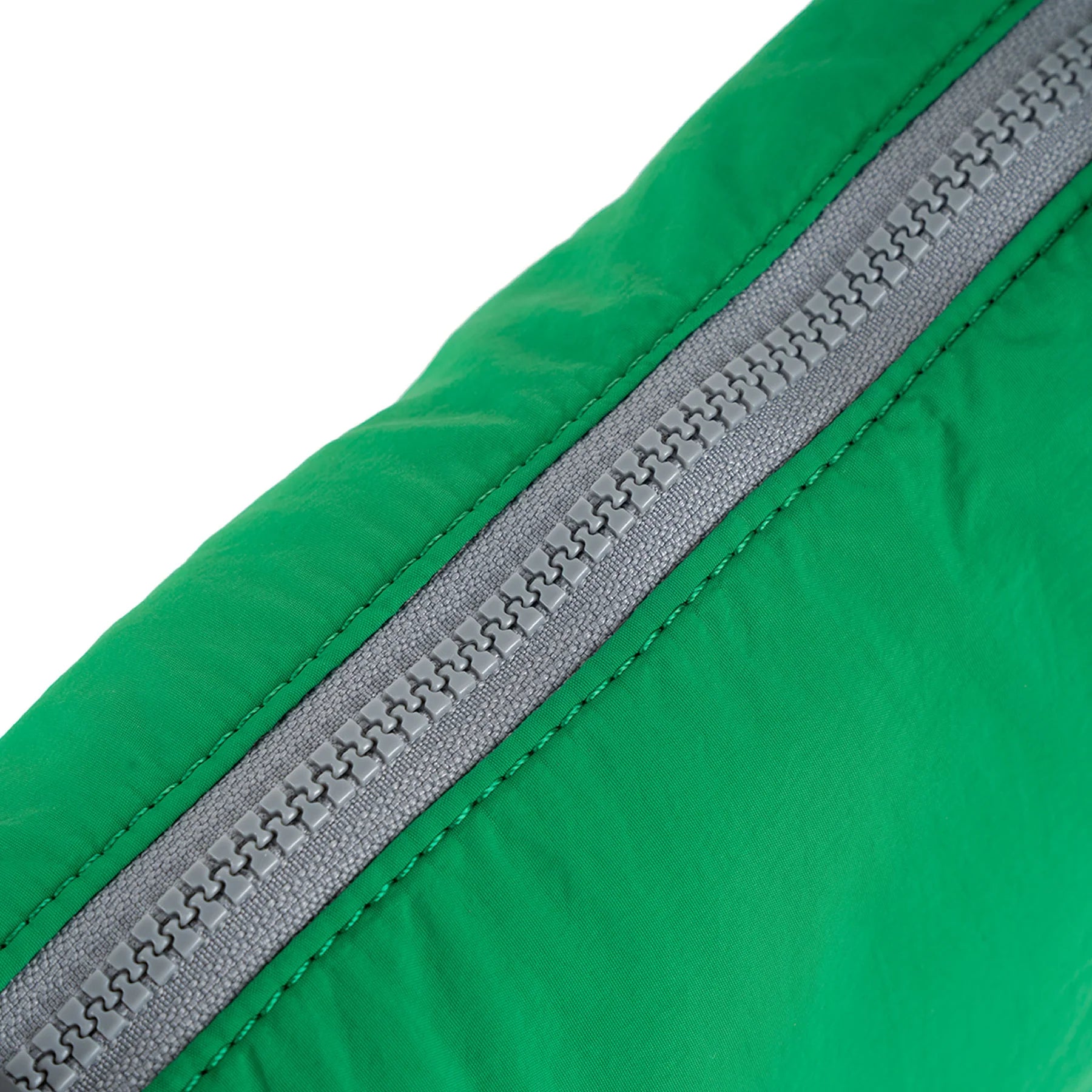 Close-up of a bright green fabric with a gray zipper.
