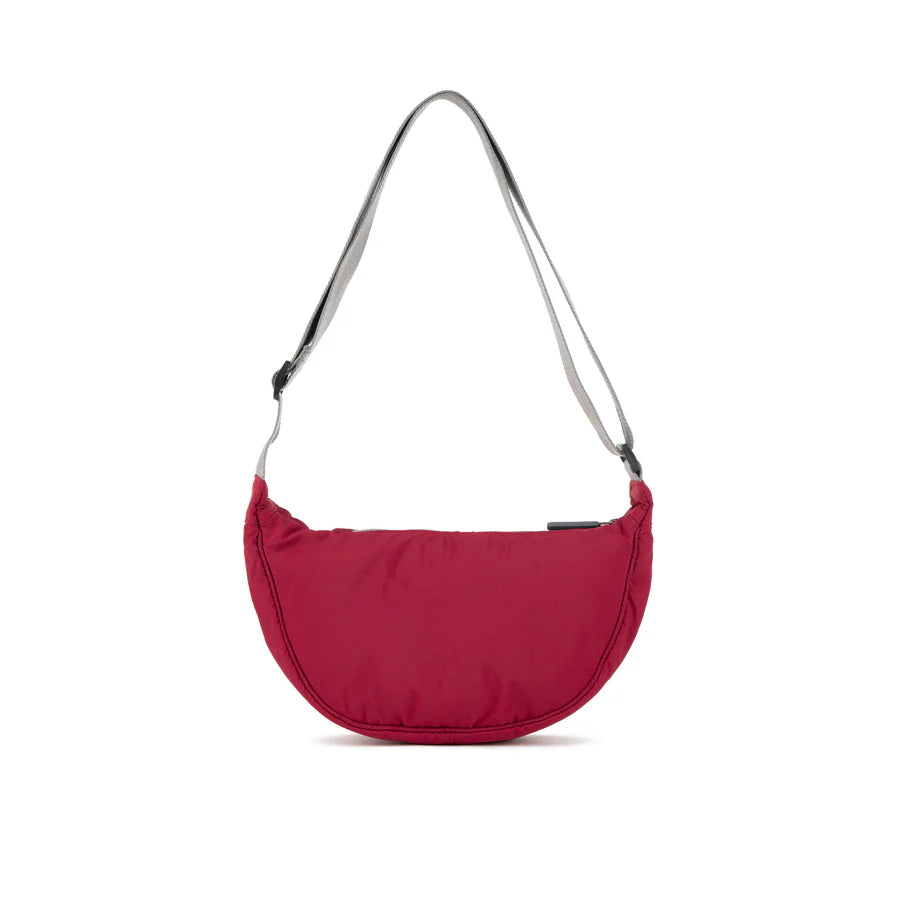 Crimson half-moon crossbody bag with gray shoulder strap.