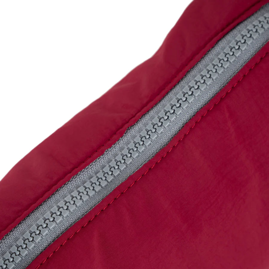Close-up of a burgundy fabric with a gray zipper.