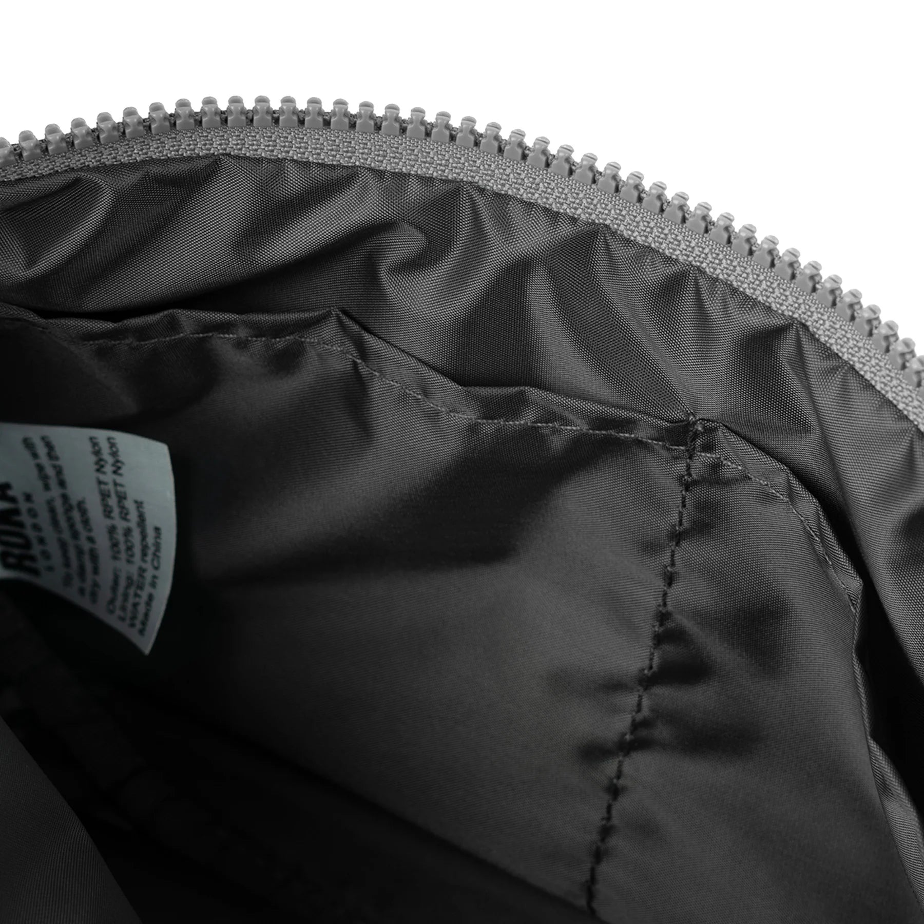 Close-up of a black jacket with a zipper and label on a white background