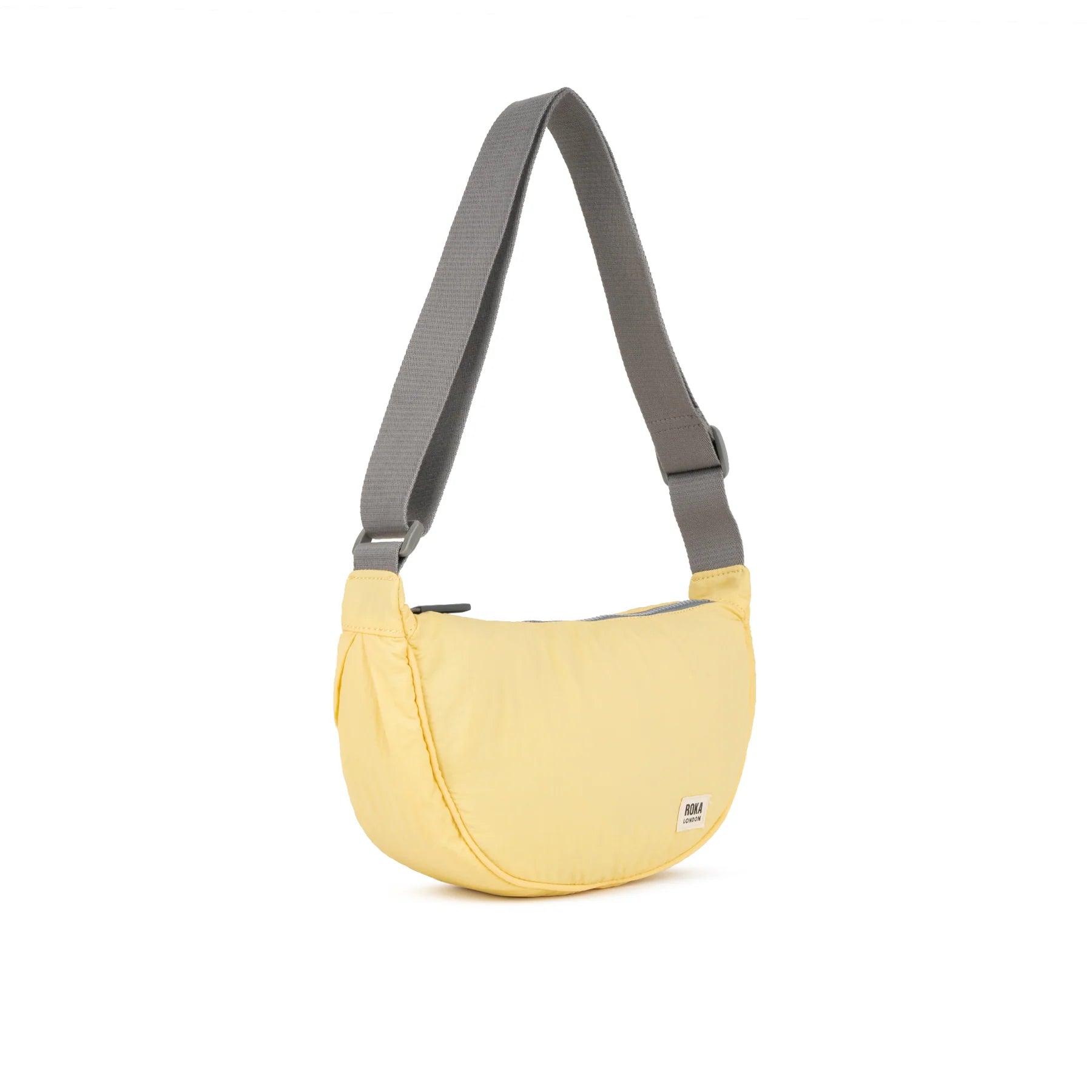 A light yellow crescent-shaped shoulder bag with a gray adjustable strap, shown on a plain white background.