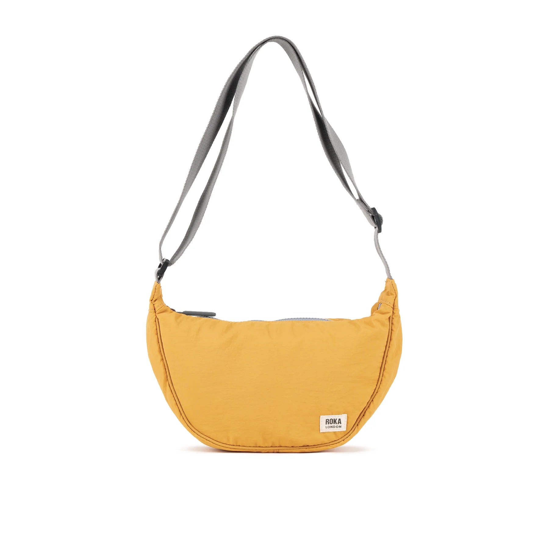 Mustard yellow crescent-shaped crossbody bag with gray shoulder strap and small brand label.